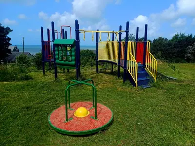 a group of playground equipment in the grass at CABIN 8 Pet friendly Family glamping Seaview in Llwyngwril