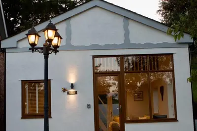 a street light in front of a white house at Honey Bee Cottage Tiny House Welshpool in Welshpool