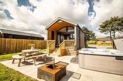 a tiny house with a hot tub on a patio at Daverneithon 3 in Rhayader