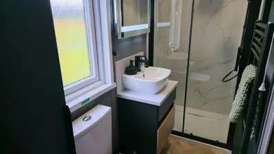 a bathroom with a sink and a glass shower at Daverneithon 2 in Rhayader