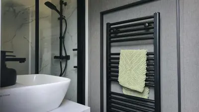 a bathroom with a white sink and a towel rack at Daverneithon 4 in Rhayader