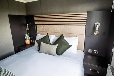 a bedroom with a white bed with green pillows at Daverneithon 4 in Rhayader