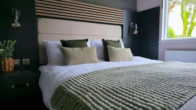 a bedroom with a large white bed with a window at Daverneithon 4 in Rhayader