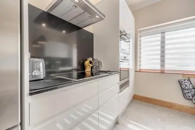 a kitchen with white cabinets and a stove top oven at 2 Bed in Llanybydder oc-b32255 in Cwrt-newydd