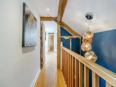 a hallway with blue walls and a wooden staircase at Pen Y Groes in Welshpool