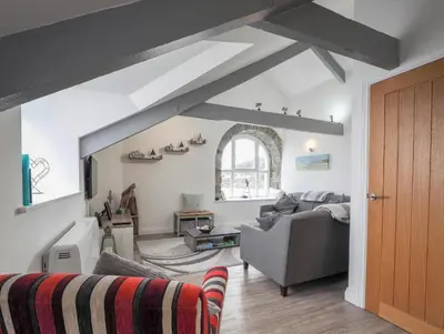 a living room with a couch and a chair at Sailhouse Loft New Quay in New Quay