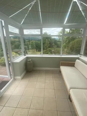 a conservatory with a couch in a room with windows at Brecon with Spectacular Views in Brecon