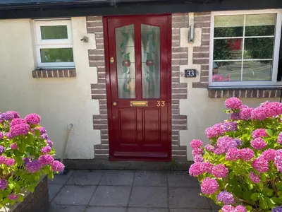 a red door on a house with purple flowers at Brecon with Spectacular Views in Brecon