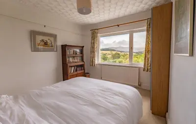 a bedroom with a white bed and a window at Brecon with Spectacular Views in Brecon