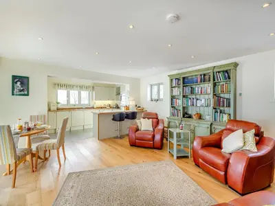 a living room with two chairs and a table and a kitchen at Orchard Barn in Llandrindod Wells