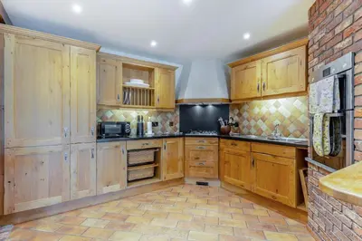 a kitchen with wooden cabinets and a brick wall at 4 Bed in Talybont oc-y32384 in Talybont