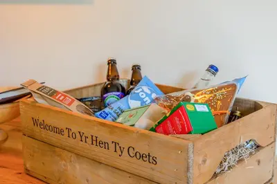 a wooden crate filled with drinks and books on a table at 4 Bed in Talybont oc-y32384 in Talybont