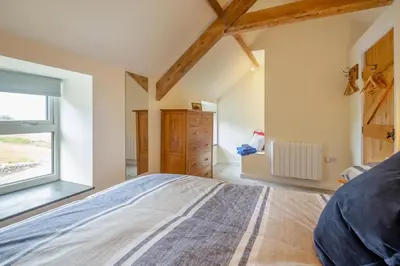 a bedroom with a large bed and a window at 3 Bed in Tywyn oc-b32570 in Llangelynin