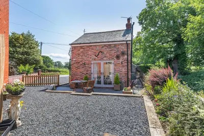 an exterior view of a brick house with a gravel driveway at 2 Bed in Carreghofa oc-t32530 in Llanymynech