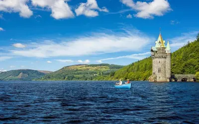two people in a boat on a lake with a castle at 2 Bed in Carreghofa oc-t32530 in Llanymynech