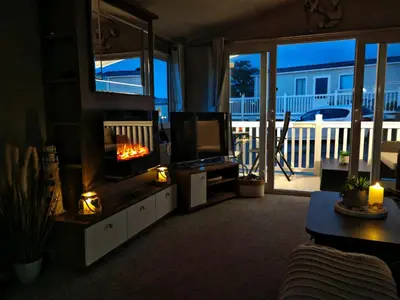 a living room with a fireplace and a television at The Ocean Nook in New Quay