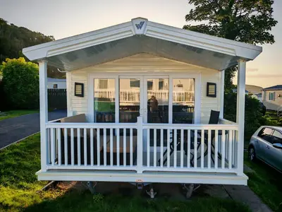 a white screened in porch with a roof at The Ocean Nook in New Quay