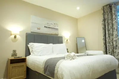 a bedroom with a large bed with white sheets at The Barmouth Bar & Grill in Barmouth