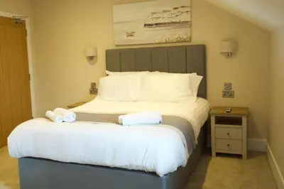 a bedroom with a large bed with two towels on it at The Barmouth Bar & Grill in Barmouth