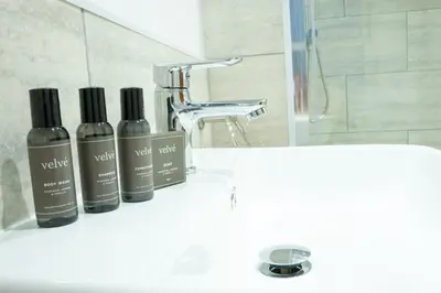 a bathroom sink with two bottles ofodorizers on it at The Barmouth Bar & Grill in Barmouth