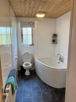 a bathroom with a white tub and a toilet at Perfect getaway Cabin Haf with Hot Tub in Llanrhaeadr-ym-Mochnant