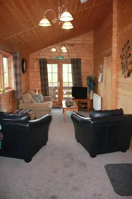 a living room with two leather couches and a tv at Perfect getaway Cabin Haf with Hot Tub in Llanrhaeadr-ym-Mochnant