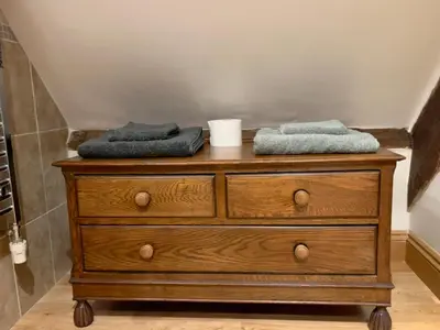 a wooden dresser with two towels on top of it at Rooftops Loft in Hay-on-Wye