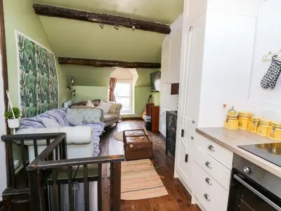 a kitchen with a living room with a couch at The Little Laura Ashley House in Machynlleth