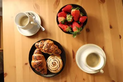 a table with two plates of pastries and a bowl of strawberries at Vern Dale Cottage, Erwood, River Wye, Builth Wells in Builth Wells