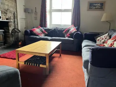 a living room with couches and a coffee table at Large farmhouse in Snowdonia, North Wales in Talsarnau