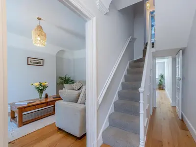 a staircase in a living room with a couch and a table at Spring Gardens in New Quay