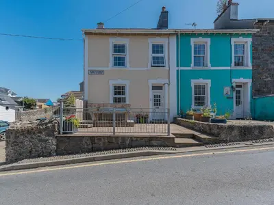 a blue and white house on the side of a street at Spring Gardens in New Quay