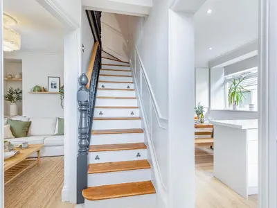 a staircase in a home with white walls and wooden floors at Lansdowne House in Brecon