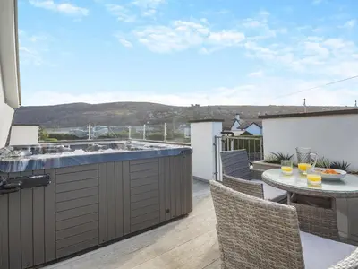 a balcony with a kitchen and a table with chairs at Hafod Y Morfa - Uk48829 in Harlech