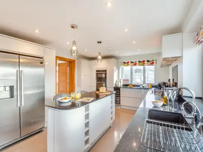 a kitchen with white cabinets and stainless steel appliances at Hafod Y Morfa - Uk48829 in Harlech
