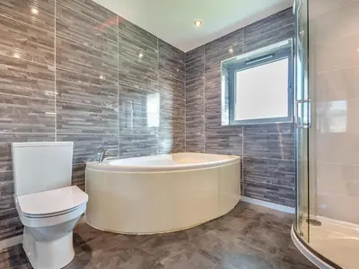 a bathroom with a tub and a toilet at Hafod Y Morfa - Uk48829 in Harlech