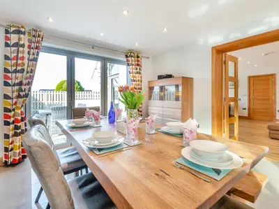 a dining room with a wooden table with chairs at Hafod Y Morfa - Uk48829 in Harlech