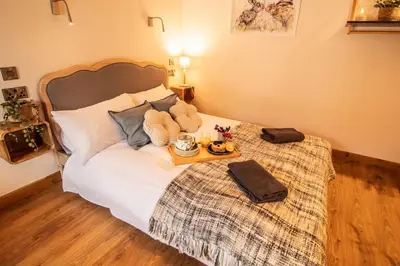 a bedroom with a bed with a tray of food on it at Wyns Barn in Rhayader