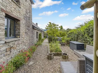 a stone house with a garden and a stone building at Hays Boathouse-Maes-Y-Caer in Hay-on-Wye