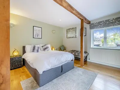 a bedroom with a large bed and a window at Hays Boathouse-Maes-Y-Caer in Hay-on-Wye