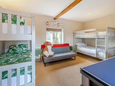 a bedroom with bunk beds and a teddy bear on a couch at Hays Boathouse-Maes-Y-Caer in Hay-on-Wye