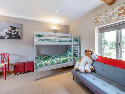 a childs bedroom with bunk beds and a stuffed animal at Hays Boathouse-Maes-Y-Caer in Hay-on-Wye
