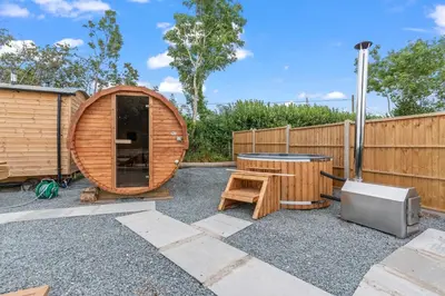 a circular wooden sauna with a table and a tv at Starry Nights Escape - Hot Tub & Sauna in Yarpole