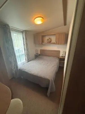 a small bedroom with a bed and a window at Green Heaven at Clarach Bay Spacious 3 BedPet Friendly Luxury Steps from the Sea in Aberystwyth