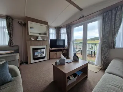 a living room with a couch and a tv and a fireplace at Green Heaven at Clarach Bay Spacious 3 BedPet Friendly Luxury Steps from the Sea in Aberystwyth
