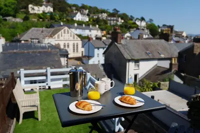 a table with two plates of food and two glasses of orange juice at Mousehole in Aberdyfi Charming Seaside Fisherman's Cottage in Aberdyfi