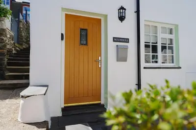 a wooden door on the side of a house at Mousehole in Aberdyfi Charming Seaside Fisherman's Cottage in Aberdyfi