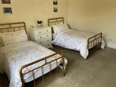 a bedroom with two beds and a dresser at Town centre Victorian period 3 bedroom home in Bishops Castle