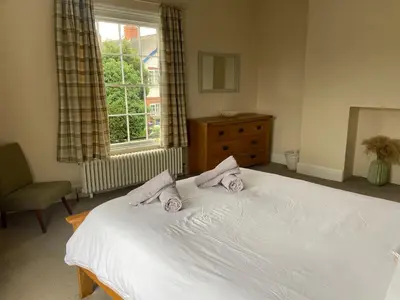 a bedroom with a white bed with two pillows on it at Town centre Victorian period 3 bedroom home in Bishops Castle