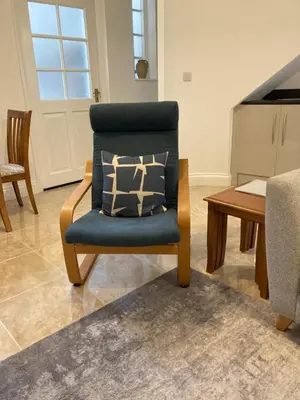 a blue chair with a pillow in a living room at Ludford View, riverside cottage in Ludlow with private parking in Ludlow